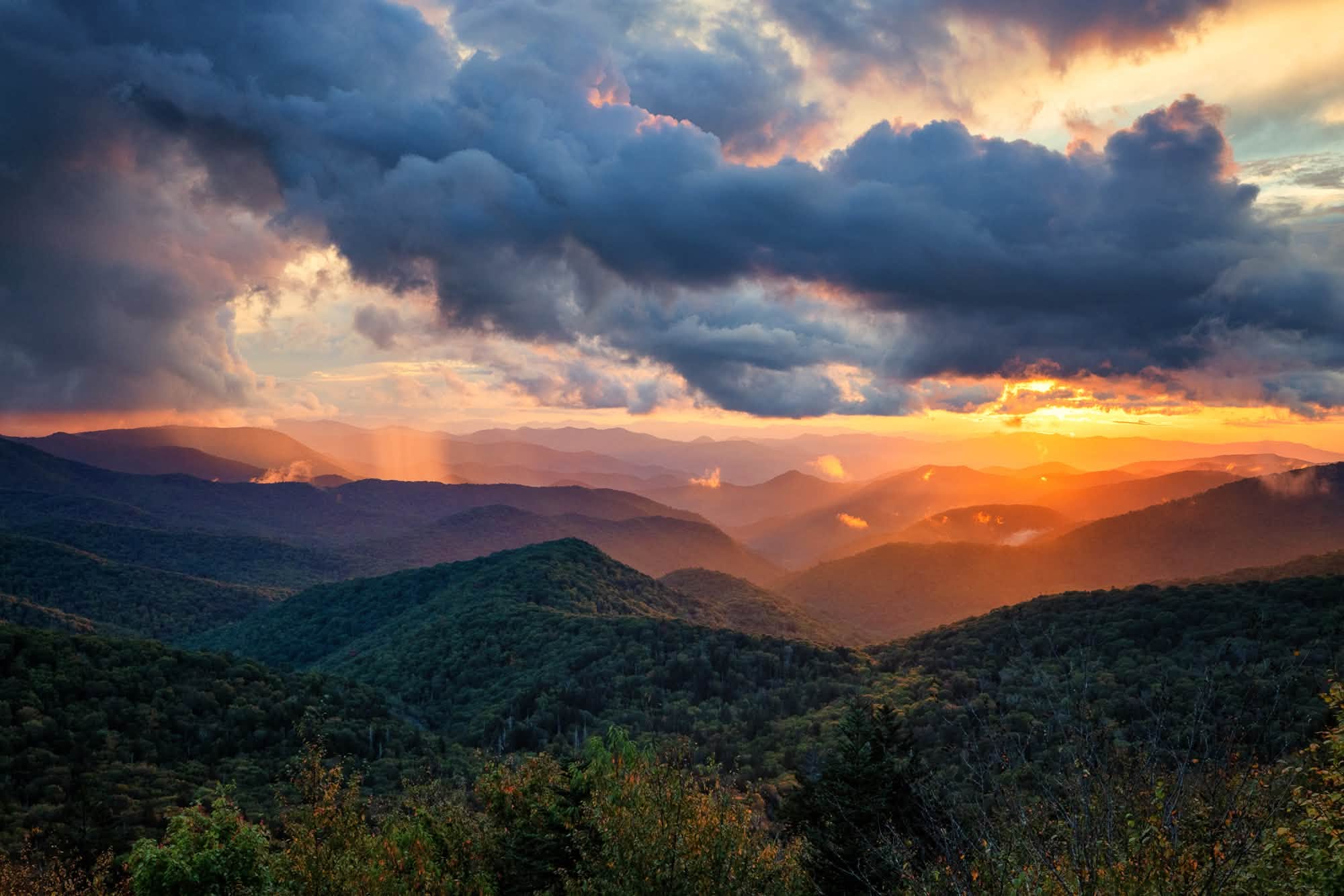 Mountain ridgelines at sunset beneath dramatic clouds